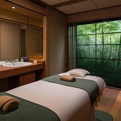 A luxurious spa room featuring a single massage bed, with a neatly arranged towel placed on top, offering a calm and inviting atmosphere