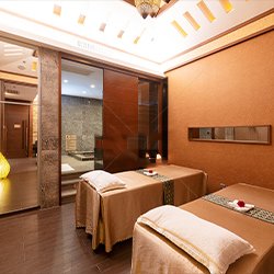 A luxurious spa room with two massage beds, each thoughtfully adorned with gifts, creating a serene and welcoming atmosphere for guests.